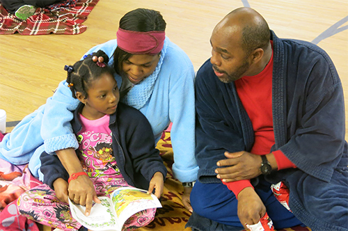 Family reads together at Books and Pajamas Family Literacy Fun Night