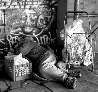 homeless man lying on city street